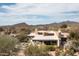 Aerial view features a desert home with mountain backdrop and cloudy blue sky at 10687 E Fernwood Ln, Scottsdale, AZ 85262
