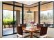 Inviting dining area with a wooden table, woven chairs, large windows and a view of the patio at 10687 E Fernwood Ln, Scottsdale, AZ 85262