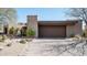 Desert home with a two-car garage and xeriscaped front yard with native plants and rock features at 10687 E Fernwood Ln, Scottsdale, AZ 85262