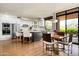 Bright kitchen with stainless steel appliances, white cabinets, island with seating, and adjacent dining area at 10687 E Fernwood Ln, Scottsdale, AZ 85262