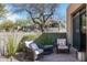 Cozy outdoor patio featuring comfortable wicker seating, a small table, and desert landscaping at 10687 E Fernwood Ln, Scottsdale, AZ 85262