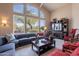 Bright living room with large windows, comfortable seating, and a stylish entertainment center creating a welcoming space at 11947 E Terra Dr, Scottsdale, AZ 85259