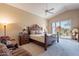 Cozy bedroom with a carved wooden bed frame, bedside tables, and a sliding door to the outdoors at 11947 E Terra Dr, Scottsdale, AZ 85259