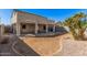 Expansive backyard view showing patio, rock landscape, and block wall fencing at 12818 W Pershing St, El Mirage, AZ 85335