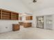 Bright living room featuring vaulted ceilings, built-in shelves and cabinets, with kitchen view and sliding glass door at 13544 W Whitewood Dr, Sun City West, AZ 85375