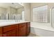 Bright bathroom with large mirror, glass block window, and soaking tub at 13615 W Merrell St, Avondale, AZ 85392