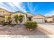Charming single-story home with a two car garage, desert landscaping, and palm trees at 13615 W Merrell St, Avondale, AZ 85392