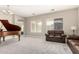Elegant living room featuring neutral tones, large windows, plush carpet, and a grand piano at 13615 W Merrell St, Avondale, AZ 85392