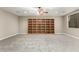 Spacious recreation room with built-in bookcases, neutral walls, plush carpet and natural light at 13615 W Merrell St, Avondale, AZ 85392