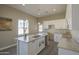 Bright kitchen features white cabinets, granite countertops, a large island, and modern pendant lighting at 14951 S Capistrano Rd, Arizona City, AZ 85123
