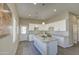 Bright kitchen features white cabinets, granite countertops, a large island, and modern pendant lighting at 14951 S Capistrano Rd, Arizona City, AZ 85123
