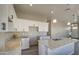 Open kitchen features white cabinets, granite countertops, a large island, and modern pendant lighting at 14951 S Capistrano Rd, Arizona City, AZ 85123