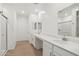 Bright bathroom featuring double sinks, quartz countertops, shower and wood look flooring at 15765 W Cheryl Dr, Waddell, AZ 85355