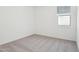 Neutral bedroom offers carpet, a window and white walls at 15765 W Cheryl Dr, Waddell, AZ 85355