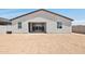 Rear of home with windows, sliding glass door, dark roof and stucco exterior at 15765 W Cheryl Dr, Waddell, AZ 85355