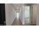 Bright hallway with tile flooring leading to carpeted bedroom and naturally lit common areas at 15765 W Cheryl Dr, Waddell, AZ 85355