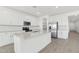 Bright kitchen features white cabinets, stainless appliances, and a large center island at 15765 W Cheryl Dr, Waddell, AZ 85355
