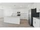Stylish kitchen with white cabinetry, an island and modern stainless steel appliances at 15765 W Cheryl Dr, Waddell, AZ 85355