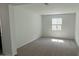 An empty room with neutral carpet, white walls, and natural light from a single window at 15765 W Cheryl Dr, Waddell, AZ 85355