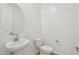 Clean powder room featuring pedestal sink, decorative mirror and toilet at 15765 W Cheryl Dr, Waddell, AZ 85355