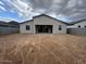 Rear exterior view of a home with a covered patio and spacious, unfinished backyard at 15778 W Cheryl Dr, Waddell, AZ 85355