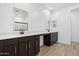 Bathroom features dual sinks, quartz countertops, dark cabinets, and wood-look tile flooring at 15778 W Cheryl Dr, Waddell, AZ 85355