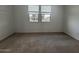 Bedroom featuring neutral carpeting and a large window for natural light at 15778 W Cheryl Dr, Waddell, AZ 85355