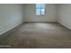 Bright, carpeted bedroom with a single window offering natural light at 15778 W Cheryl Dr, Waddell, AZ 85355