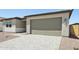 View of the home's garage with its multi-panel door, and a paver driveway, and desert landscaping at 15778 W Cheryl Dr, Waddell, AZ 85355
