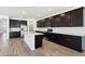 Modern kitchen boasting dark wood cabinets, a center island, stainless steel appliances, and pendant lighting at 15778 W Cheryl Dr, Waddell, AZ 85355