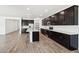 Stylish kitchen with dark cabinets, an island with a sink, stainless steel appliances, and recessed lighting at 15778 W Cheryl Dr, Waddell, AZ 85355