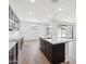 Bright kitchen with dark cabinetry, quartz countertops, and a large island at 15778 W Cheryl Dr, Waddell, AZ 85355