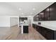 Modern kitchen boasts an island, stainless steel appliances, and sleek dark cabinetry at 15778 W Cheryl Dr, Waddell, AZ 85355