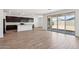 Open-concept living space showcasing hardwood floors, dark kitchen cabinets, and a sliding glass patio door at 15778 W Cheryl Dr, Waddell, AZ 85355