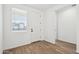 Bright living room featuring wood-look tile flooring, white walls, and a window letting in natural light at 15778 W Cheryl Dr, Waddell, AZ 85355