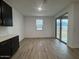 Open living area with wood flooring, a window, and sliding glass doors at 15778 W Cheryl Dr, Waddell, AZ 85355