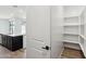 Walk-in pantry boasts white shelving for optimal storage, located just off the kitchen at 15778 W Cheryl Dr, Waddell, AZ 85355
