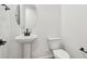 Bright powder room features a pedestal sink, toilet, and matte black fixtures at 15778 W Cheryl Dr, Waddell, AZ 85355