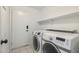 Laundry room with tile flooring, shelving, modern washing machine, and a dryer at 15825 S 1St Ave, Phoenix, AZ 85045