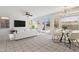 Open-plan living room features tiled floors, ceiling fan, large TV, and access to the backyard patio at 15825 S 1St Ave, Phoenix, AZ 85045