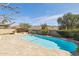 Refreshing pool surrounded by a neutral tile patio with built-in grill area and desert landscaping at 15825 S 1St Ave, Phoenix, AZ 85045