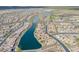 An aerial view of the community with winding streets, numerous homes, and a lake running through the middle at 15843 S 177Th Ave, Goodyear, AZ 85338