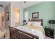 This bedroom features a wooden bed frame, green accent wall, and an ensuite bathroom at 15843 S 177Th Ave, Goodyear, AZ 85338