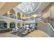 A grand lobby with a soaring ceiling, elegant chandelier, sweeping staircase, and comfortable seating areas at 15843 S 177Th Ave, Goodyear, AZ 85338