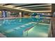 An indoor swimming pool with handrails, natural lighting, and unique design on the far wall at 15843 S 177Th Ave, Goodyear, AZ 85338