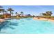 Large outdoor community pool surrounded by palm trees, chairs, and blue skies at 15843 S 177Th Ave, Goodyear, AZ 85338