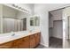 Bathroom features double sinks, wood cabinets, large mirror, and tub shower combo at 16043 W Saguaro Ln, Surprise, AZ 85374