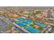 Extensive aerial view highlighting tennis courts, lush landscaping, and community amenities nestled within residential areas at 16215 W Indianola Ave, Goodyear, AZ 85395
