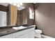 Cozy bathroom featuring a sleek vanity, decorative mirror, and tiled shower at 16215 W Indianola Ave, Goodyear, AZ 85395