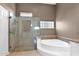 Elegant bathroom featuring a luxurious soaking tub and a separate glass-enclosed shower at 16215 W Indianola Ave, Goodyear, AZ 85395